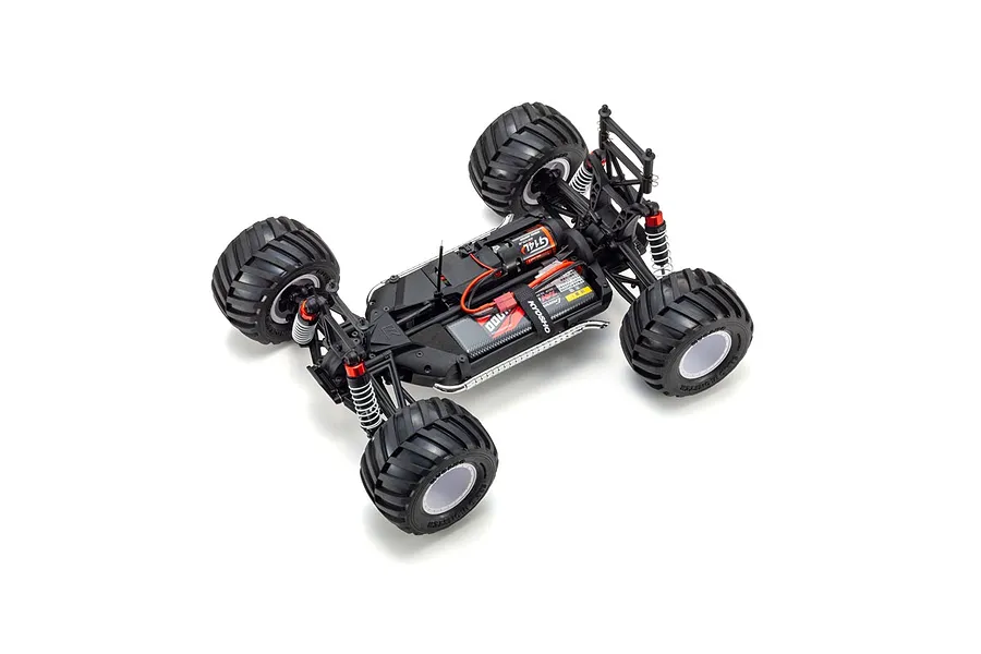 High-angle studio shot of a Kyosho Mad Van RC monster truck chassis showing the motor, battery, and suspension components.
