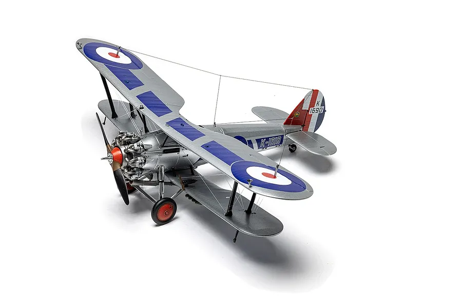 A completed 1/48 scale model of a Bristol Bulldog Mk.IIA biplane fighter, painted silver with blue and red RAF roundels and markings.