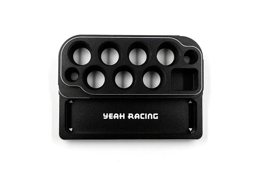 A black Yeah Racing aluminium tool stand with various circular holes for tools and a rectangular tray area, viewed from directly above.