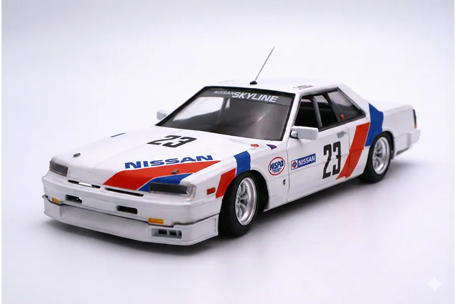 A 1/24 scale model of a white 1986 Nissan Skyline RS Turbo race car with red and blue racing livery and number 23 decals.