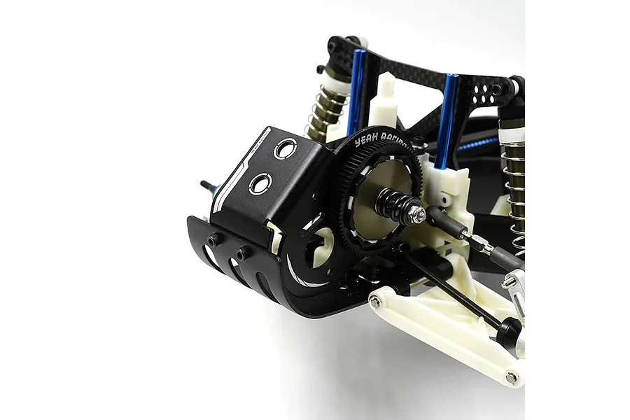 A close-up view of a black aluminium motor mount plate installed on an RC car chassis, featuring the Yeah Racing logo and gear assembly.