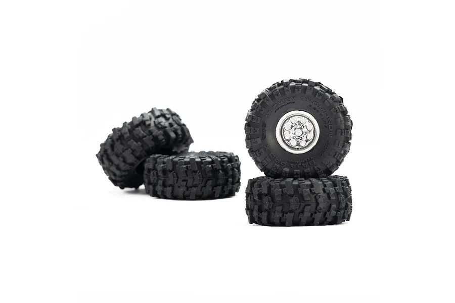 Four Pro-Line 1/30 scale RC wheels with chrome rims and black Baja Pro X tyres stacked and arranged on a white background.
