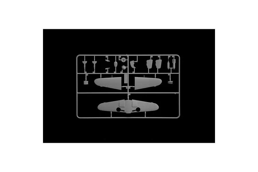 A grey plastic sprue containing various aircraft model parts, including wing sections and small components, set against a black background.
