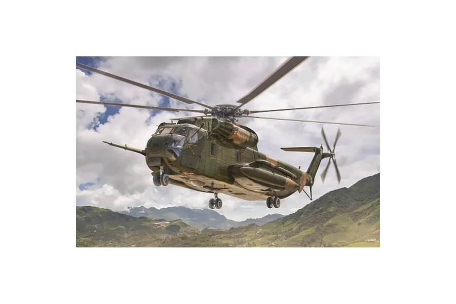 A detailed scale model of an HH-53C Jolly Green Giant helicopter in flight over a mountainous landscape.