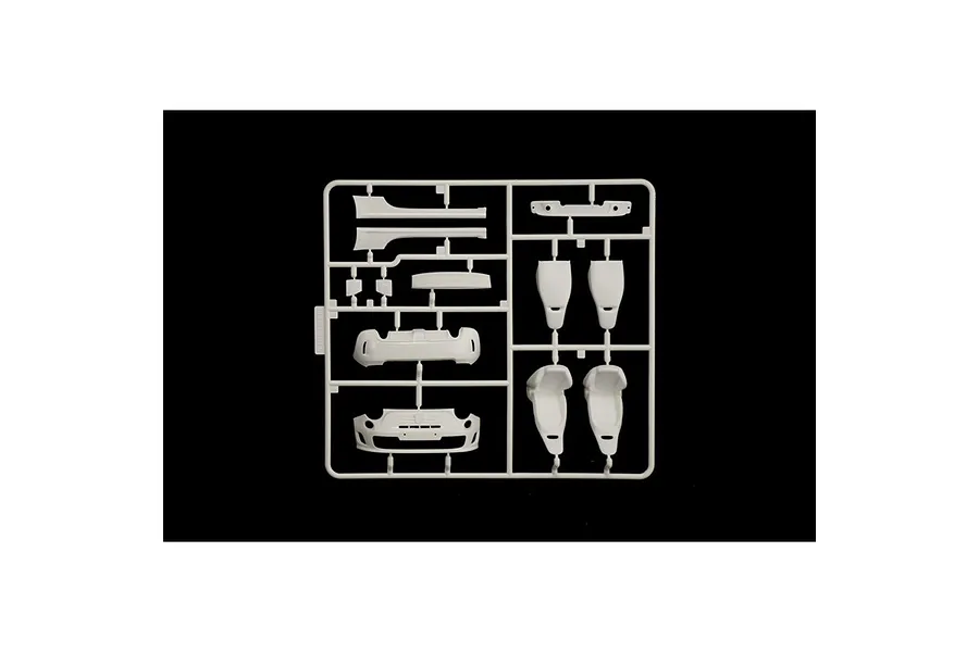 A white plastic model kit sprue containing car parts including seats and bumper sections for a 1/24 scale model car.