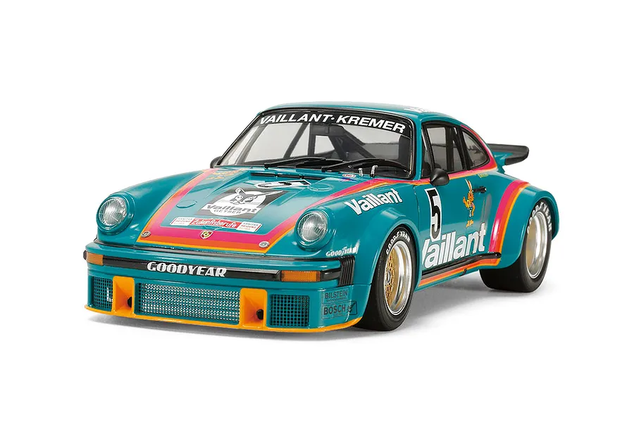 A studio shot of a 1/24 scale Tamiya Porsche 934 Turbo RSR Vaillant model car in teal with orange and pink racing stripes and Vaillant branding.