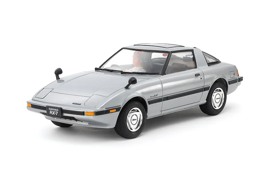 A fully assembled and painted 1/24 scale Tamiya Mazda Savanna RX-7 model car in silver, shown from a front three-quarter angle on a white background.