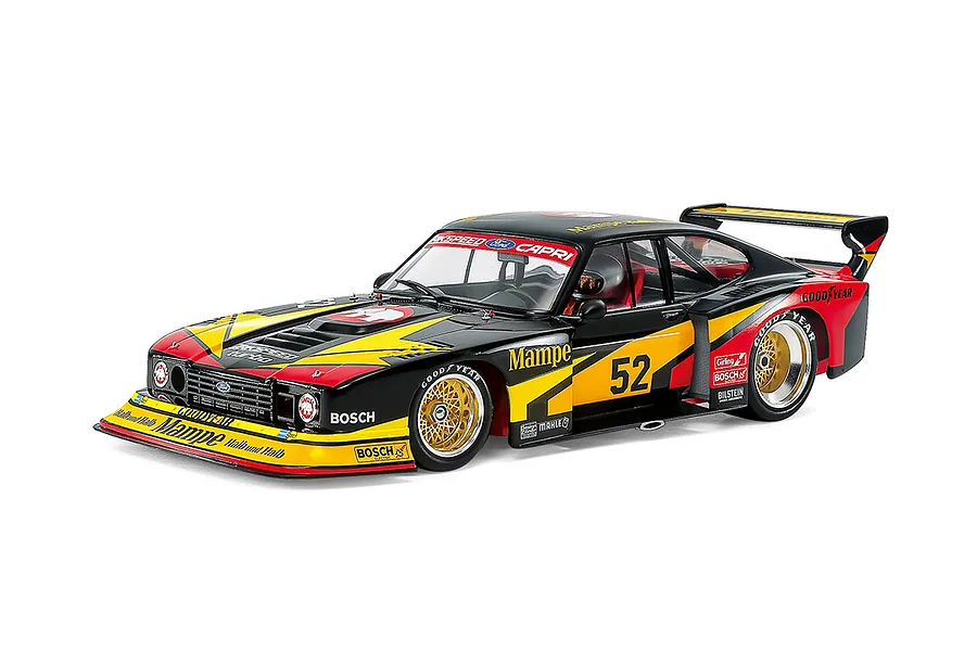 A studio shot of a fully assembled and painted 1/24 scale Tamiya 1978 Ford Zakspeed Capri Turbo model car, featuring a black, yellow, and red livery.