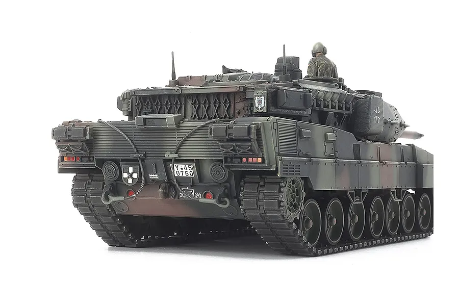 Rear view of a Tamiya 1/48 scale Leopard 2 A7V model tank featuring camouflage paint, a tank commander figure, and detailed rear hull components.