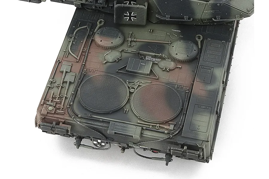 Top-down view of the rear engine deck of a Tamiya 1/48 scale Leopard 2 A7V tank model, showing detailed camouflage paint and molded tools.