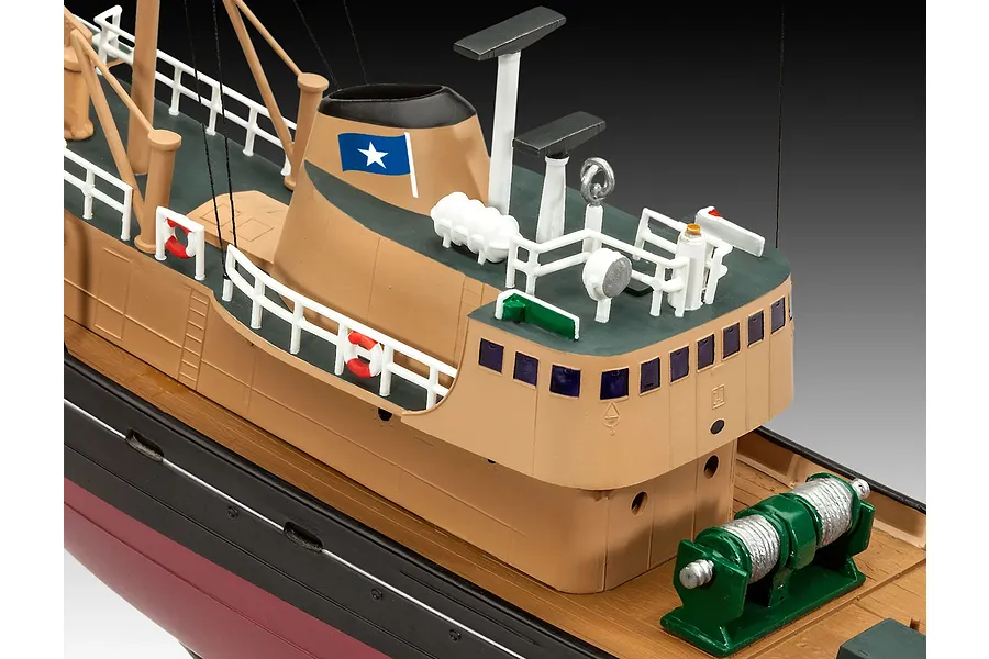 A close-up view of a painted plastic model Northsea fishing trawler, showing the bridge, funnel with a blue flag, railings, and deck equipment.