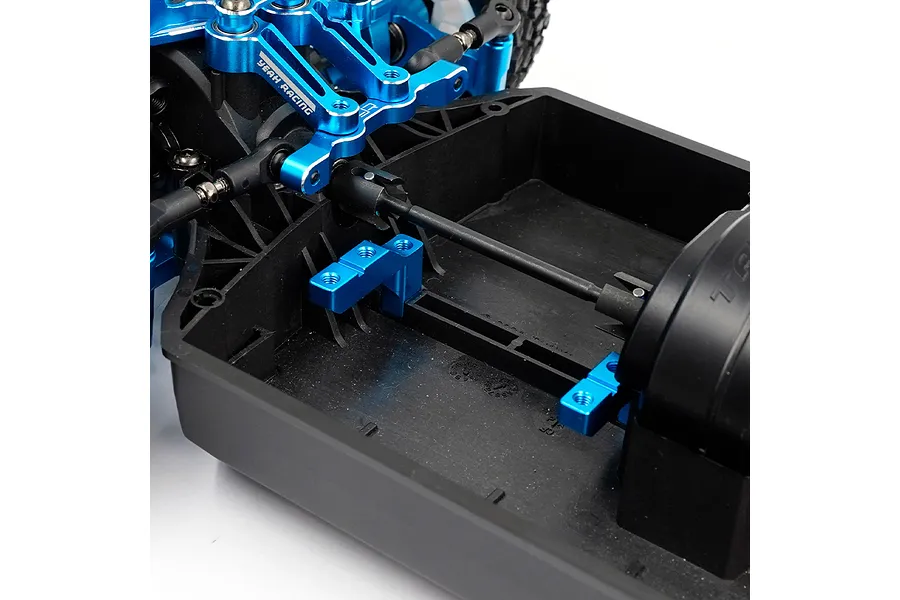 Close-up of blue anodized aluminium servo mounts installed on a black RC car chassis.