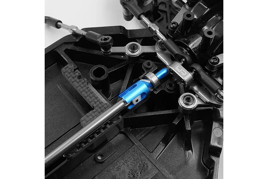 Close-up of a blue aluminium outdrive cup installed on an RC car chassis drivetrain assembly.