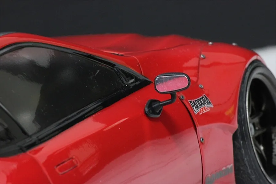 Close-up of a black side mirror mounted on a red 1/10 scale RC car body shell.