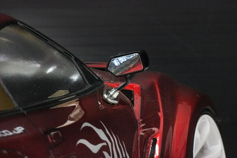 Close-up of a Pandora RC S-GT-F1 style side mirror mounted on a metallic red RC drift car body shell.