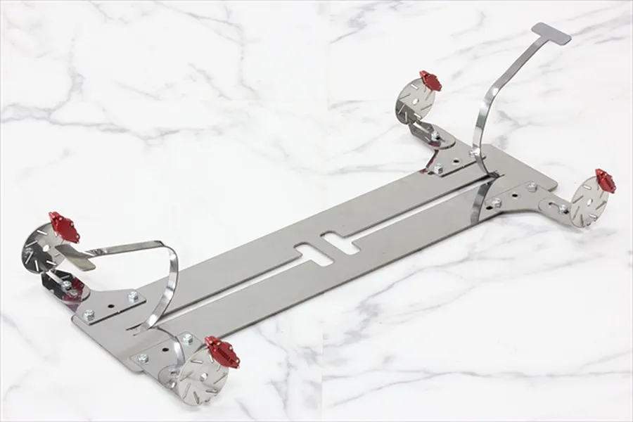 A set of four red RC brake calipers mounted on metal brackets and circular brake discs, displayed on a white marble surface.