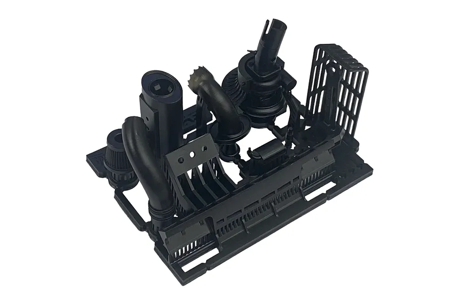 A black plastic sprue containing various RC car muffler and exhaust components for a Pandora RC RWB Rotana body shell.