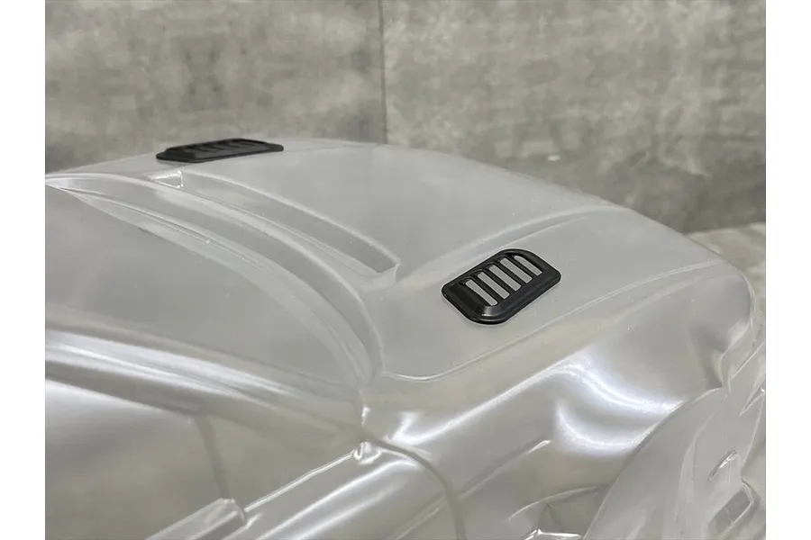 Two black bonnet duct accessories installed on a clear, unpainted 1/10 scale RC car body shell.