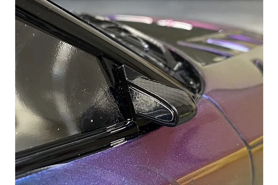Close-up of a carbon-style aero door mirror mounted on a purple RC car body shell.