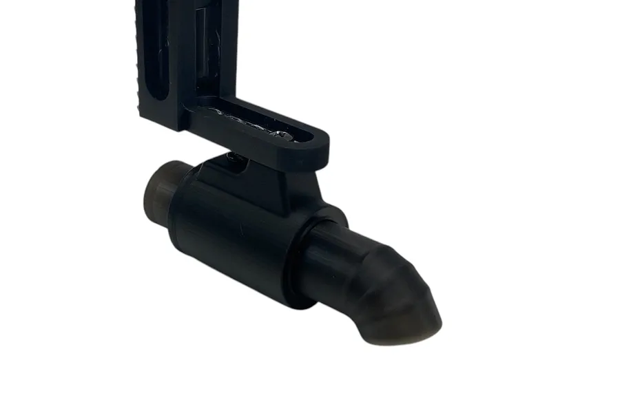 A black 3D-printed style RC single muffler accessory attached to a mounting bracket against a white background.