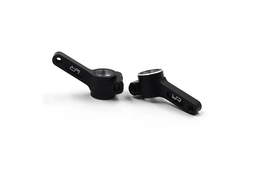 Two black anodized aluminium rear hubs for RC cars by Yeah Racing, featuring the YR logo engraved on the arms.