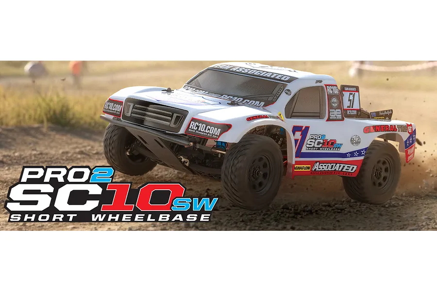 Team Associated Pro2 SC10sw RC short course truck driving on a dirt track with white body and racing decals.