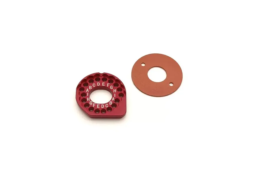 A red anodized aluminium Kyosho motor mount with gear mesh adjustment holes and a circular gasket on a white background.