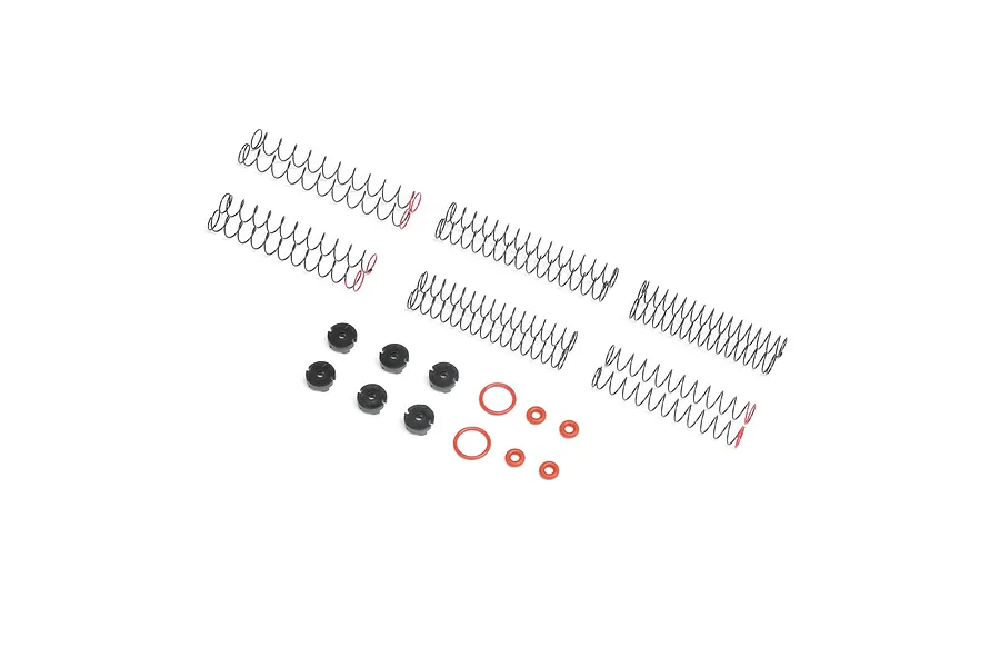 Axial shock tuning and rebuild kit containing various metal coil springs, black plastic shock pistons, and small red rubber O-rings on a white background.