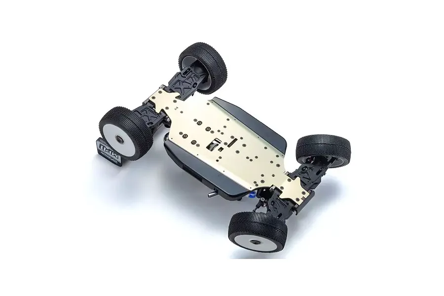 Bottom view of a Kyosho Inferno MP11 1/8 scale nitro RC buggy chassis showing the metal base plate, suspension arms, and off-road tires.