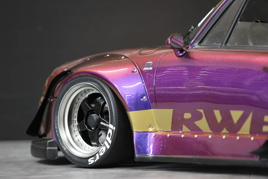 Close-up of a purple and gold RC car body featuring Idlers tyre decals on the front wheel.