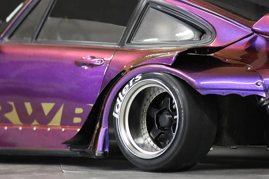 Close-up of a purple RWB RC car body showing the Idlers tyre decal applied to the sidewall of the rear tyre.