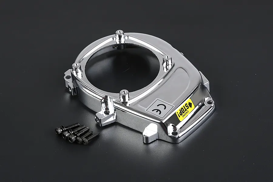 A chrome-plated Rovan RC engine cover with a yellow engine stop sticker and four included mounting screws on a dark background.