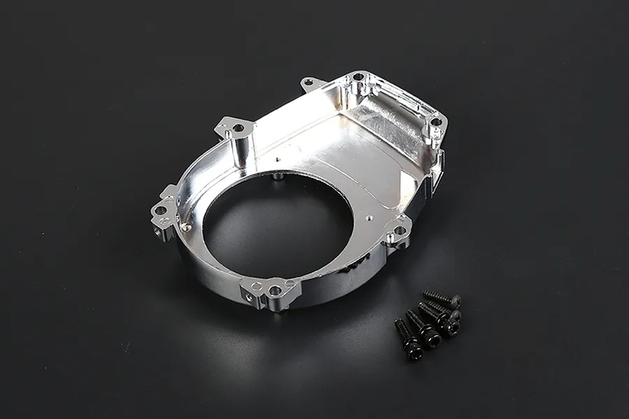 A chrome-finished RC engine cover with mounting holes and a set of four small black screws on a dark background.