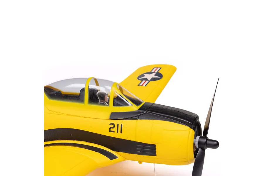 Close-up of the cockpit and nose section of a yellow and black HobbyZone T-28 Trojan RC plane with a pilot figure visible.