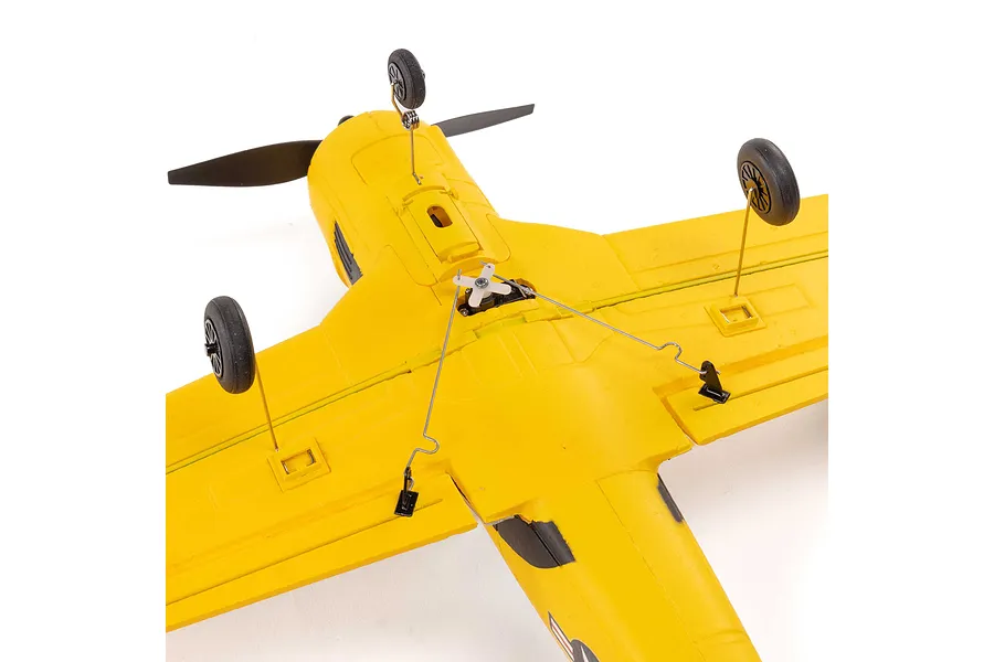 Underside view of a yellow HobbyZone T-28 Trojan RC plane showing the landing gear, wing servos, and control linkages.