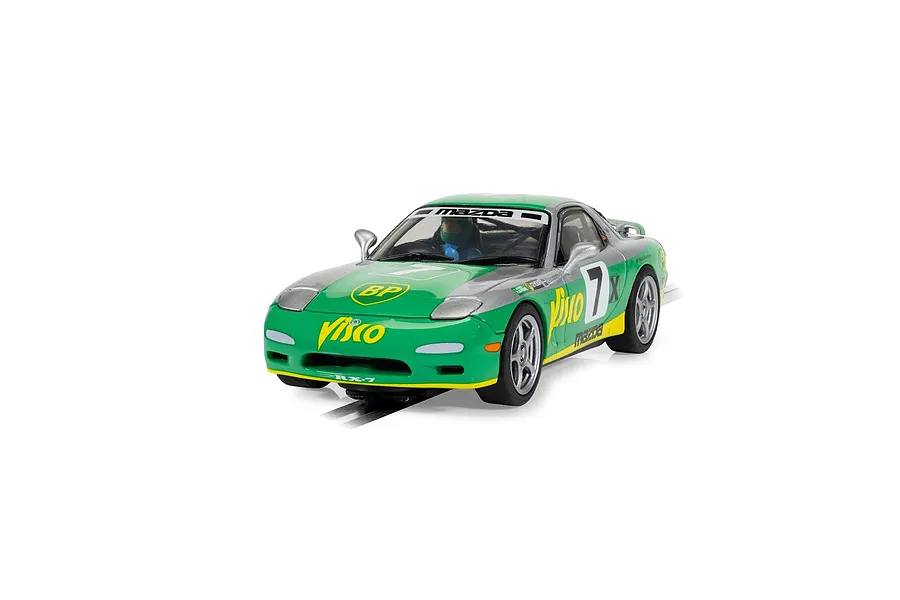 A 1/32 scale Scalextric Mazda RX-7 FD slot car in green and silver livery with number 7, displayed on a section of black slot car track.
