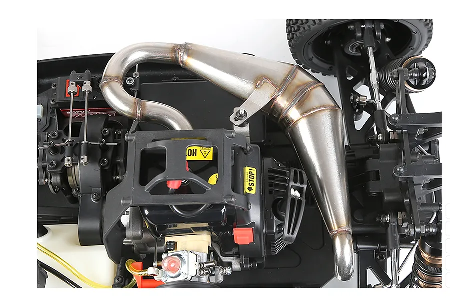 Top-down view of a Rovan RC car chassis showing the installed stainless steel tuned exhaust pipe and internal engine components.