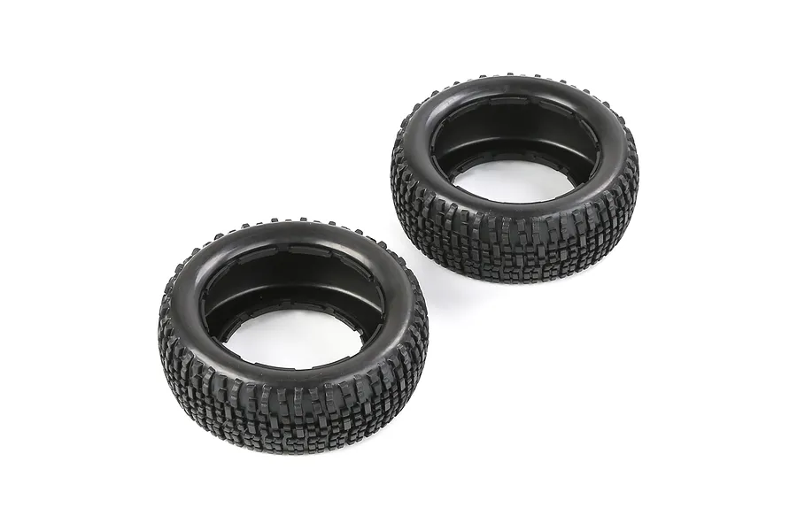 Two black rubber RC short course truck tyres with a blocky tread pattern, viewed from an angle against a white background.