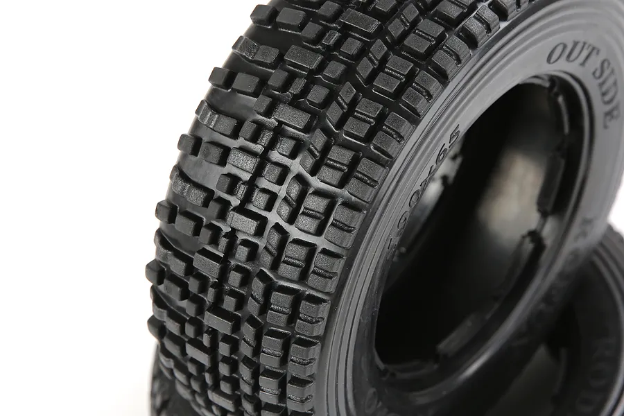 Close-up of Rovan 1/5 scale RC short course truck front tyres with a blocky tread pattern, showing the sidewall markings.