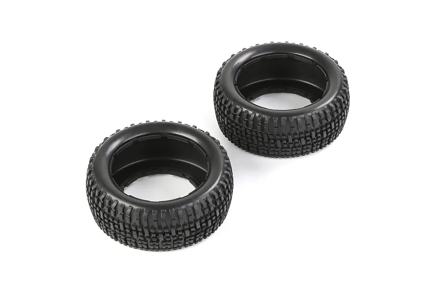 Two black rubber RC short course truck tyres with a blocky tread pattern, shown from an elevated angle on a white background.