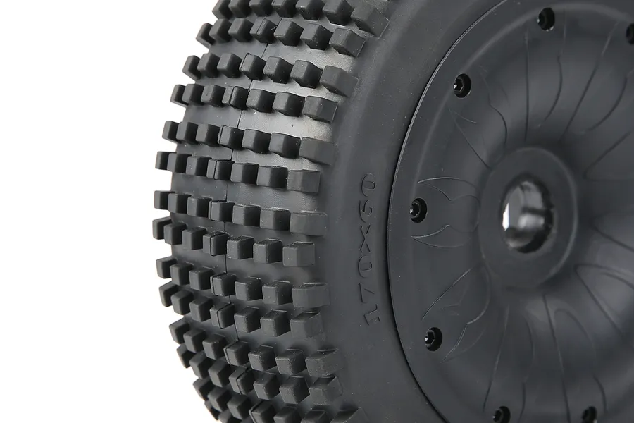 Close-up of a black RC buggy wheel with a knobby Dirt Buster tread pattern and a closed black rim.