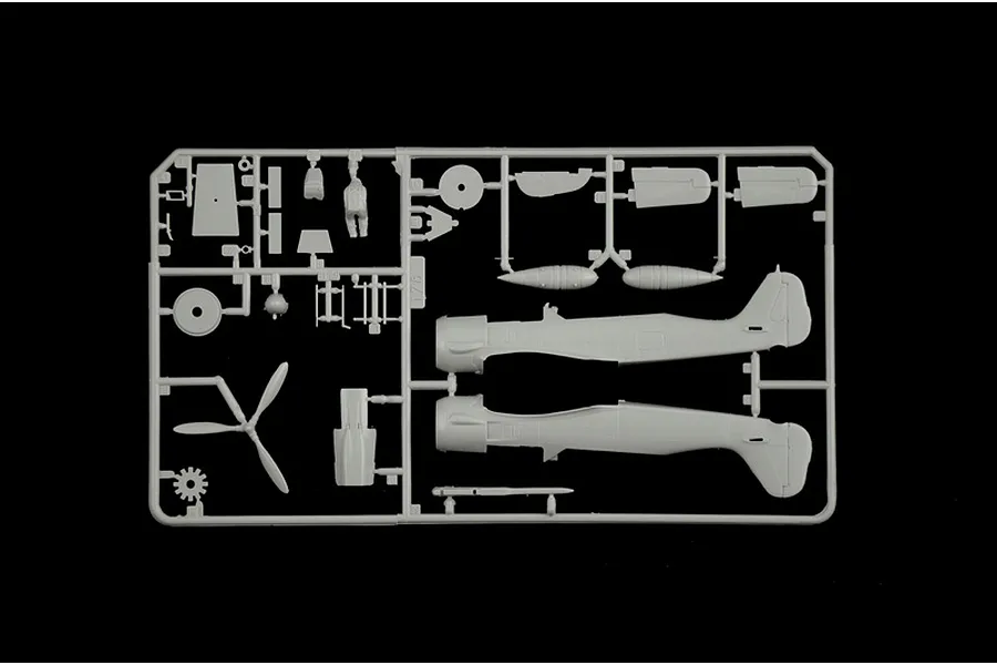 A grey plastic sprue from an Italeri 1/72 scale model aircraft kit, featuring fuselage halves, a propeller, and various small cockpit and engine parts.