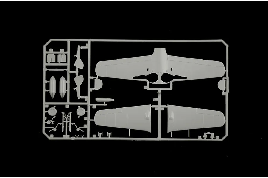 A grey plastic sprue containing model aircraft parts, including wings and landing gear components, set against a black background.