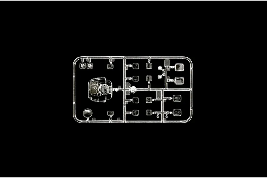 A clear plastic sprue containing transparent model helicopter parts, including a cockpit canopy and various windows, set against a black background.