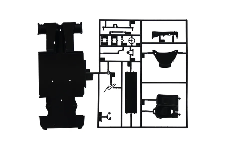 A black plastic model kit sprue containing various car parts including a chassis plate, steering wheel, and seat, isolated on a white background.