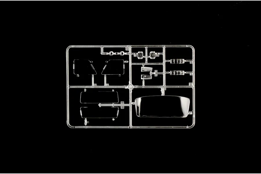 A clear plastic sprue containing various transparent model car parts, including windows and light lenses, set against a solid black background.