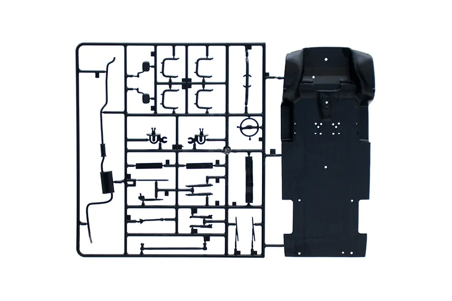 A black plastic sprue containing various model car parts, including a chassis floor pan and suspension components, for an Italeri 1/24 Ford Transit model kit.