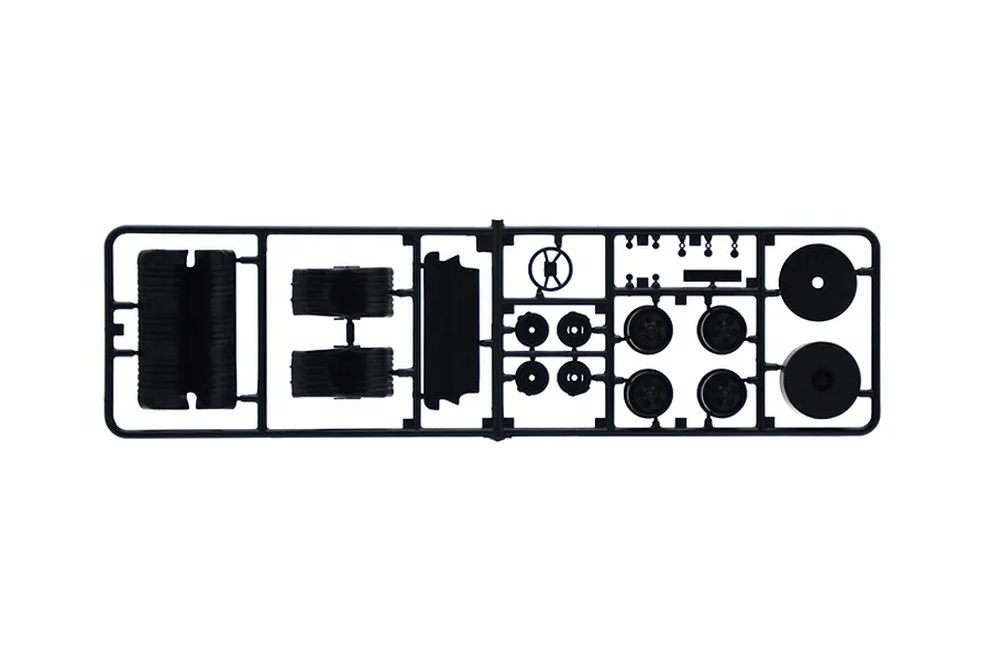A black plastic sprue containing various model car parts including wheels, tires, and a steering wheel for a 1/24 scale model kit.