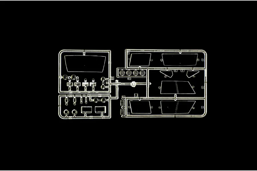A clear plastic sprue containing various transparent model car parts, including windows and light lenses, set against a black background.