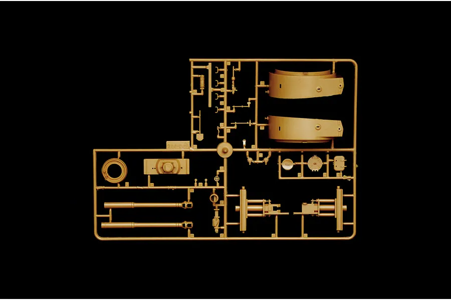 A tan plastic sprue containing various model tank parts, including turret sections and gun barrels, against a black background.